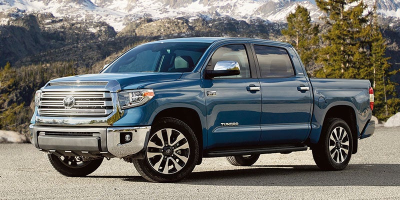 Side view of a blue 2021 Toyota Tundra parked in front of mountains