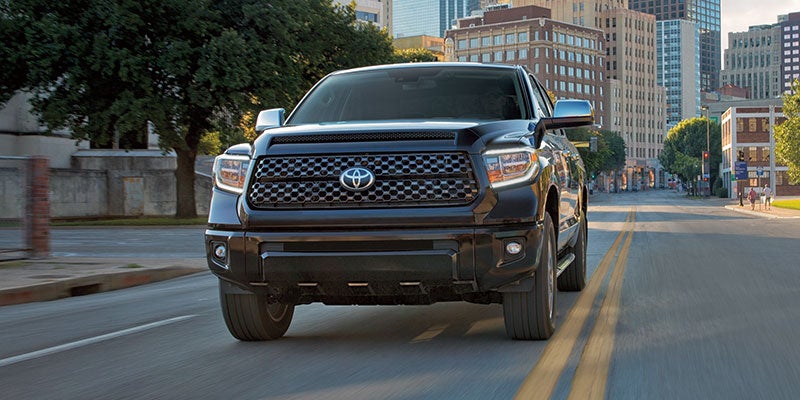 Front view of a black 2021 Toyota Tundra driving down a city street