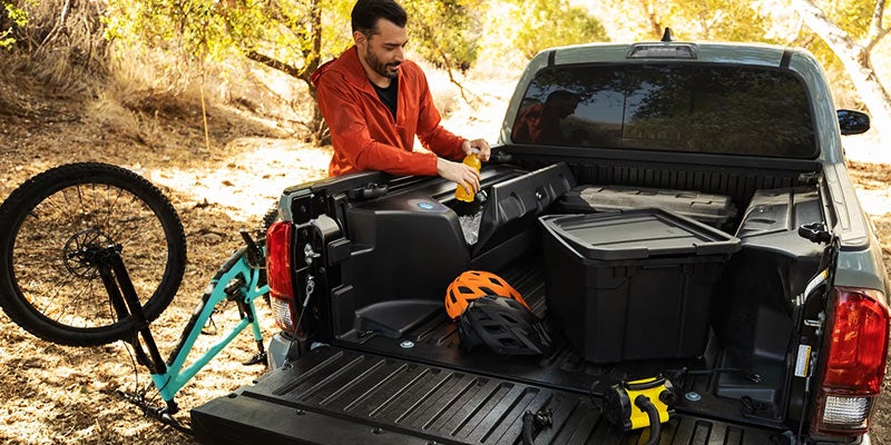 A man packs the back of a Toyota Tacoma